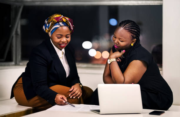 Shot of two business women discussing over some contract document in office